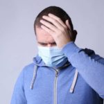 Man wearing mask and feeling unwell