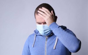 Man wearing mask and feeling unwell